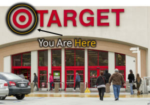 Photograph of the entrance to a Target store with shoppers going in and out; the Target bullseye logo is circled in yellow and an arrow labelled “You Are Here” points to it